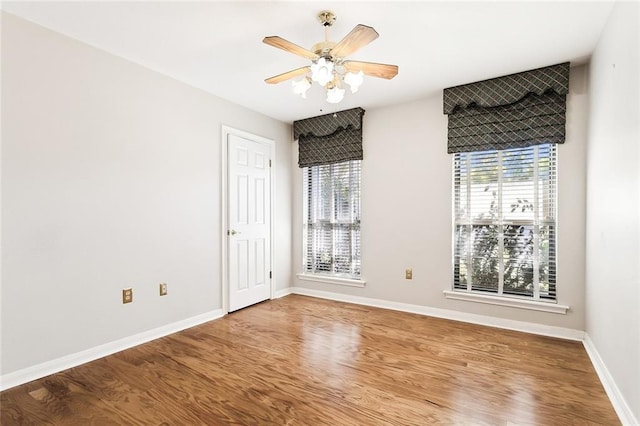 empty room featuring hardwood / wood-style floors, a healthy amount of sunlight, and ceiling fan