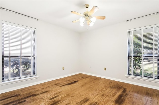 unfurnished room featuring hardwood / wood-style flooring, ceiling fan, and a wealth of natural light