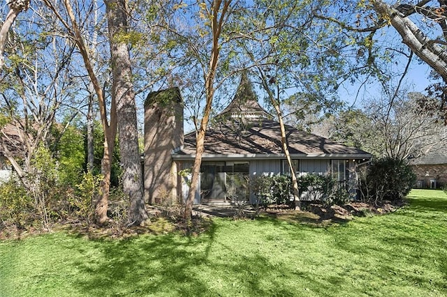 back of property featuring a yard and a sunroom