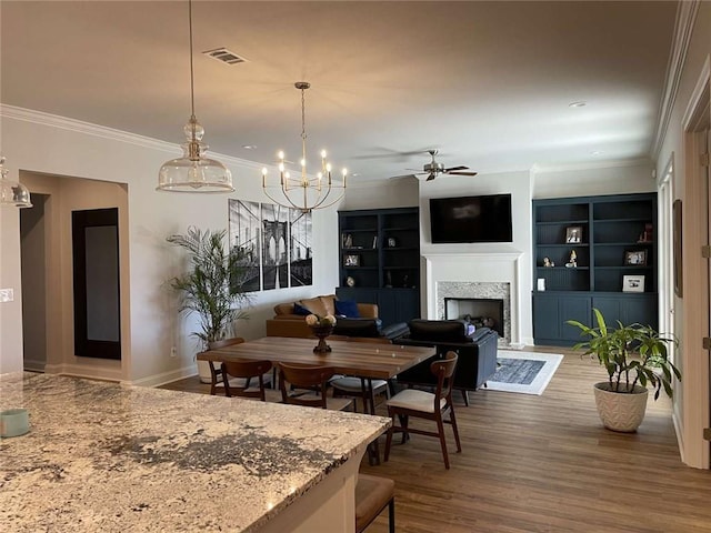 dining space with crown molding, wood-type flooring, and ceiling fan