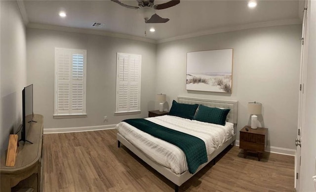 bedroom featuring hardwood / wood-style flooring, ceiling fan, and ornamental molding