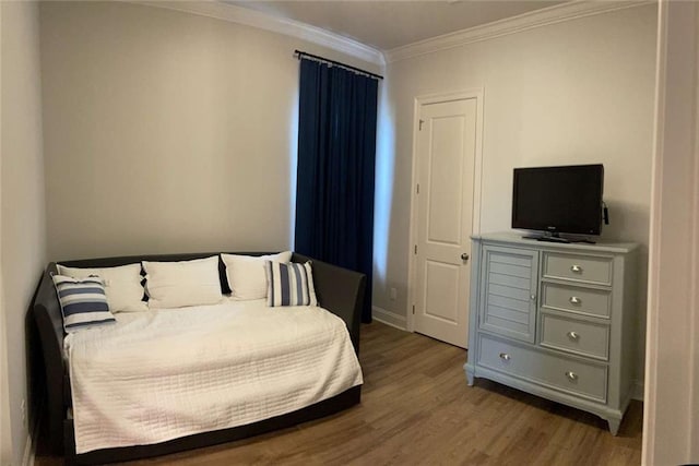 bedroom with crown molding and light hardwood / wood-style floors