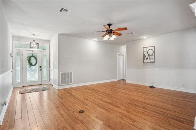 foyer entrance with wood-type flooring and ceiling fan with notable chandelier