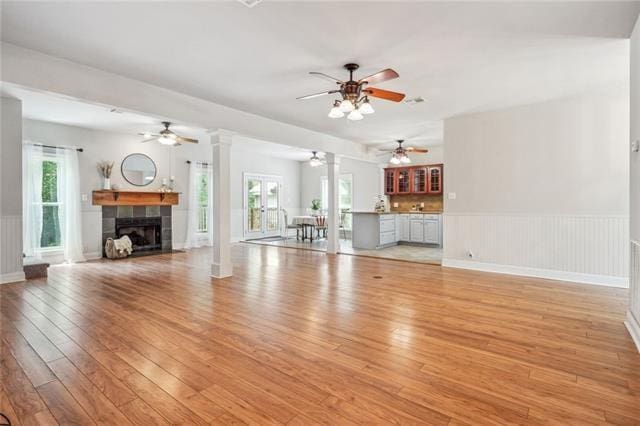 unfurnished living room with a fireplace, plenty of natural light, and light wood-type flooring