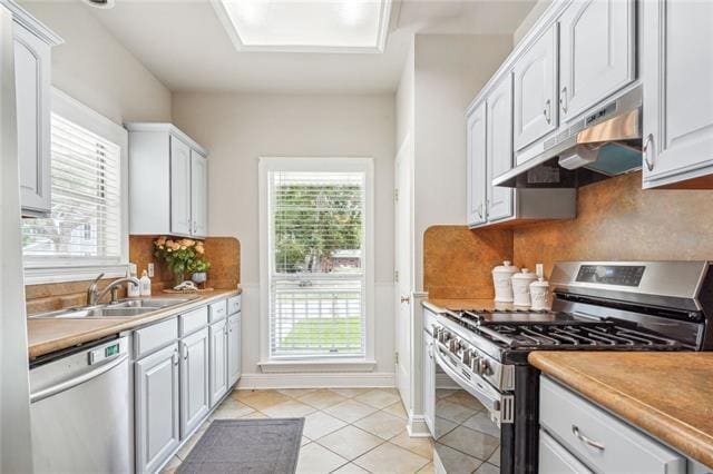 kitchen with white cabinetry, sink, backsplash, light tile patterned floors, and stainless steel appliances