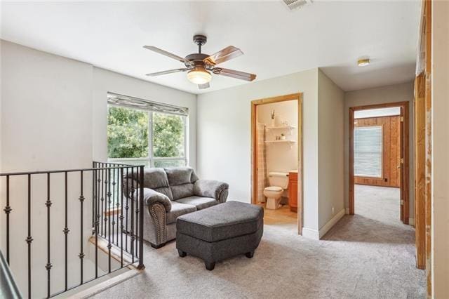 carpeted living room with ceiling fan