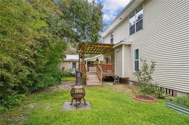 view of yard with a wooden deck, an outdoor fire pit, and a pergola