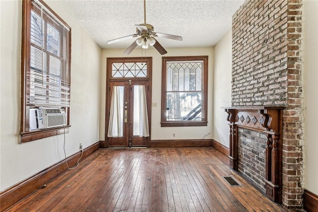 entrance foyer with cooling unit, hardwood / wood-style floors, and a textured ceiling