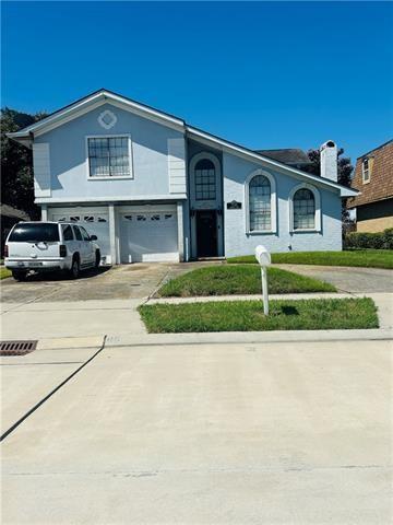 7110 Camberley Dr, New Orleans, LA 70128 - view of front of home featuring concrete driveway, an attached garage, and a chimney