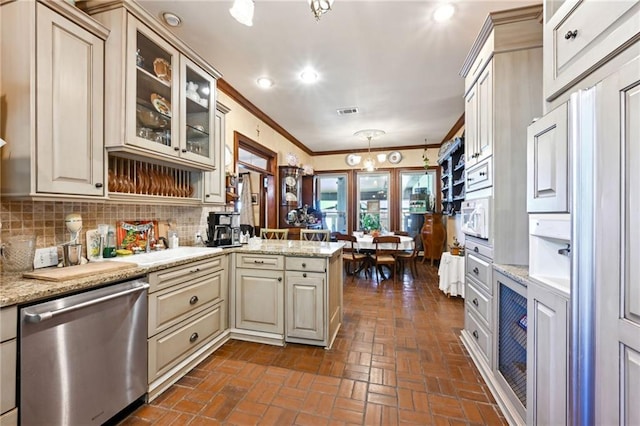 kitchen with light stone counters, hanging light fixtures, stainless steel dishwasher, and kitchen peninsula