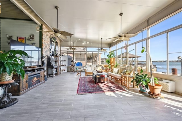 sunroom / solarium with a water view and a fireplace