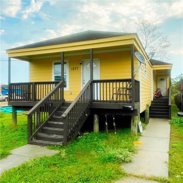 view of front of property featuring covered porch and a front lawn