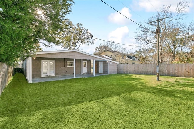 rear view of property featuring a lawn and a patio