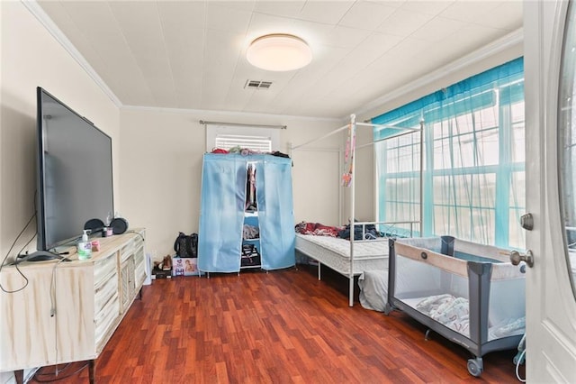 bedroom with ornamental molding and dark wood-type flooring