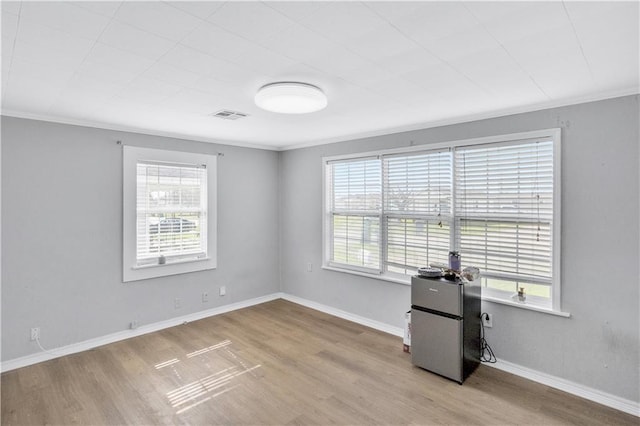 unfurnished room with ornamental molding and light hardwood / wood-style floors