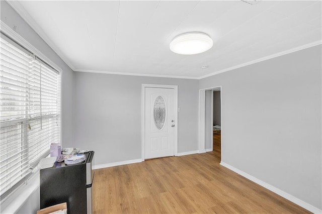 foyer with ornamental molding and light hardwood / wood-style floors