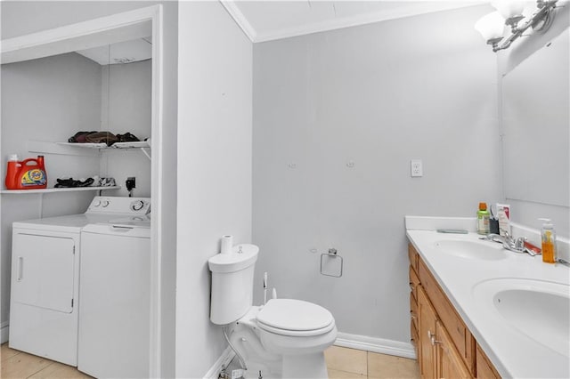 bathroom with ornamental molding, vanity, toilet, washing machine and dryer, and tile patterned floors