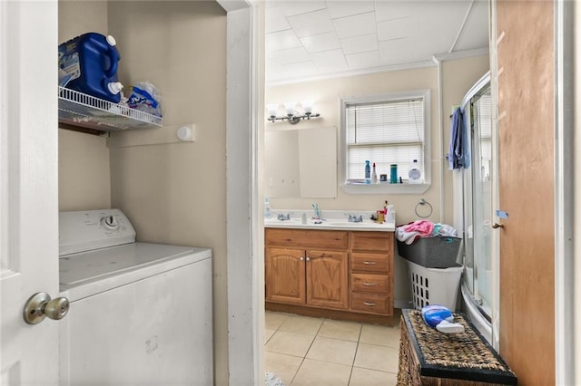 laundry room with crown molding, washer / clothes dryer, sink, and light tile patterned floors