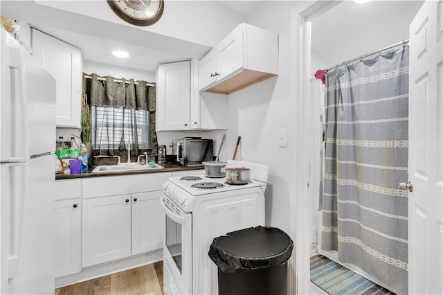 kitchen featuring sink, white cabinets, white appliances, and light hardwood / wood-style floors