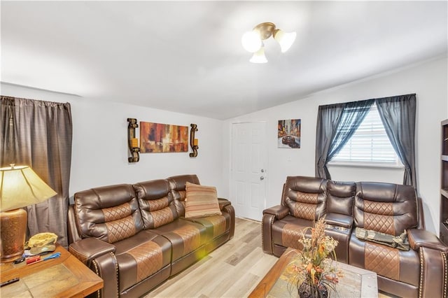 living room featuring light hardwood / wood-style flooring and vaulted ceiling