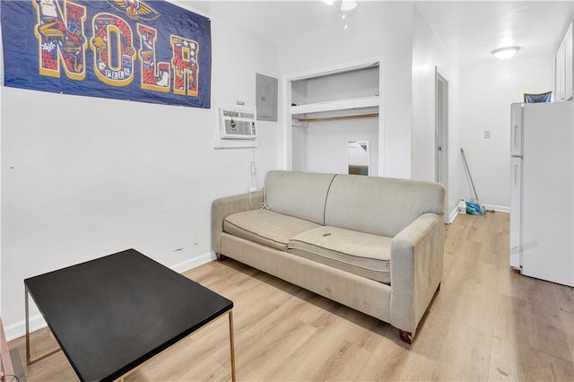 living room with a wall mounted air conditioner, hardwood / wood-style flooring, and electric panel