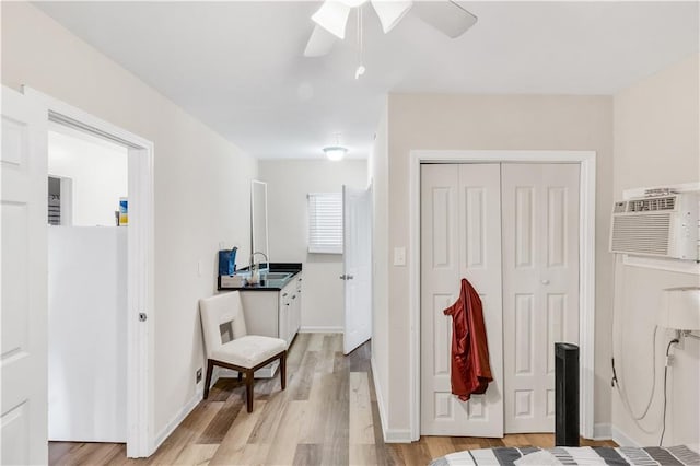 interior space featuring sink, a wall mounted air conditioner, and light hardwood / wood-style floors