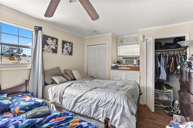 bedroom with multiple closets, ornamental molding, cooling unit, hardwood / wood-style floors, and multiple windows