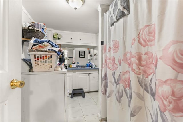 clothes washing area with light tile patterned floors