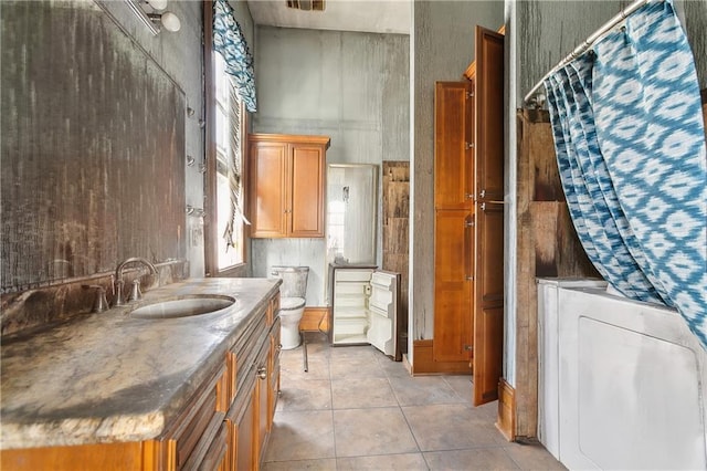 bathroom featuring washer / clothes dryer, vanity, tile patterned floors, and toilet