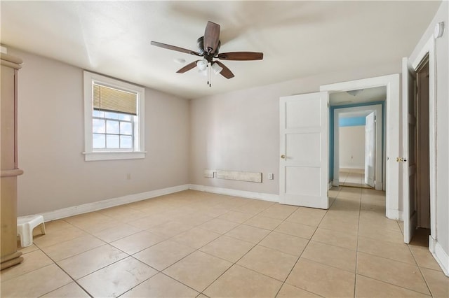 tiled spare room with ceiling fan