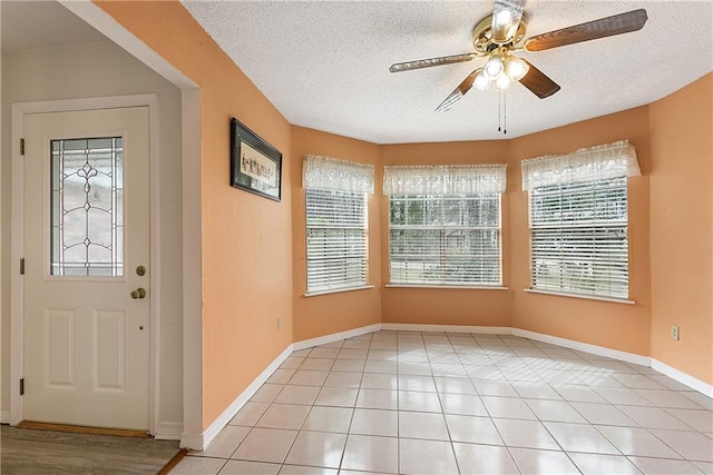 tiled foyer entrance featuring ceiling fan and a textured ceiling