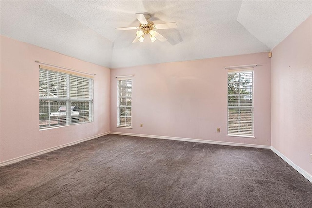 spare room featuring vaulted ceiling, ceiling fan, and dark carpet