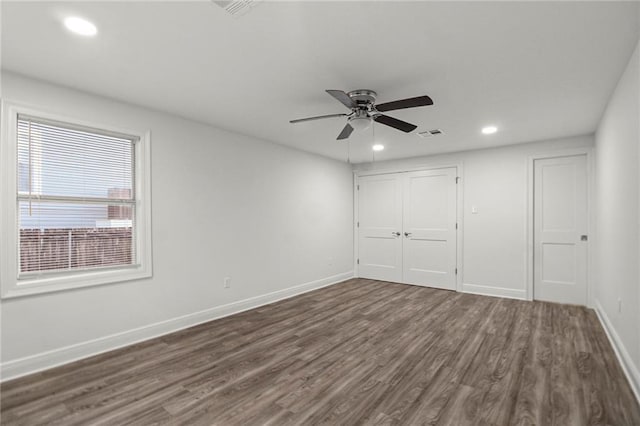 unfurnished bedroom with dark wood-type flooring, ceiling fan, and a closet