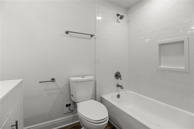 full bathroom featuring hardwood / wood-style flooring, tiled shower / bath, vanity, and toilet