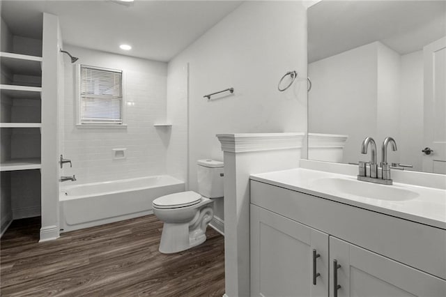 full bathroom featuring vanity, tiled shower / bath, wood-type flooring, and toilet