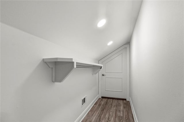 spacious closet featuring lofted ceiling and dark hardwood / wood-style floors