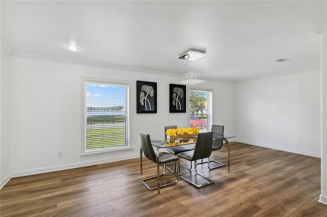 dining area featuring dark hardwood / wood-style flooring and crown molding