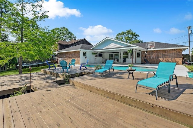 view of swimming pool featuring a trampoline and a wooden deck