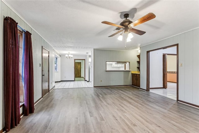 unfurnished living room with crown molding, ceiling fan with notable chandelier, and light hardwood / wood-style floors