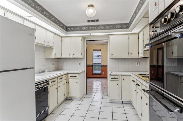 kitchen with sink, light tile patterned floors, decorative backsplash, and black appliances