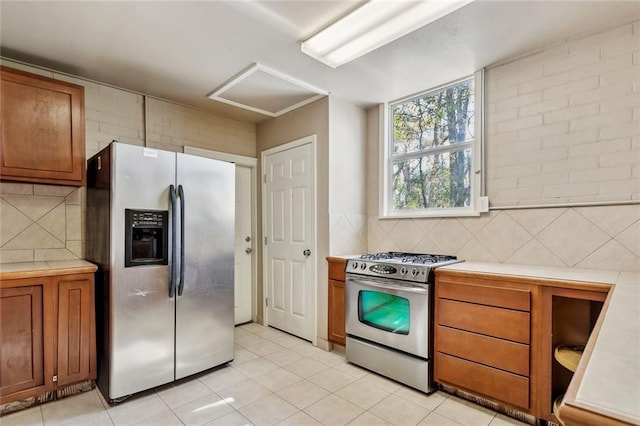 kitchen featuring stainless steel appliances, light tile patterned floors, and decorative backsplash