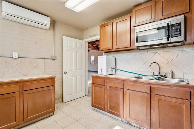 kitchen featuring backsplash, sink, a wall unit AC, and light tile patterned floors