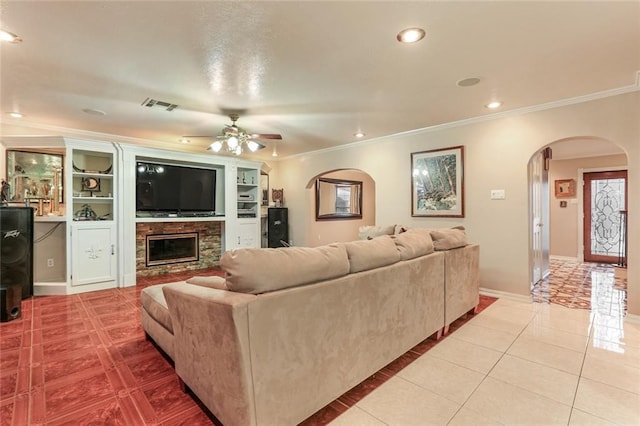 living room featuring crown molding, light tile patterned floors, ceiling fan, and a fireplace