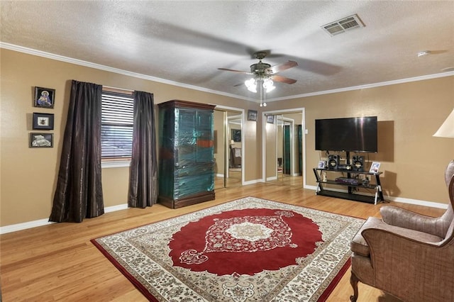 living room featuring hardwood / wood-style floors, crown molding, a textured ceiling, and ceiling fan