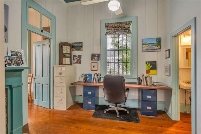 office with wood-type flooring and ceiling fan