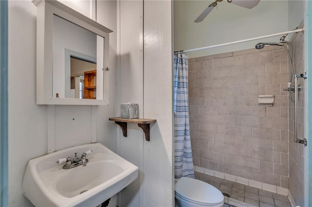 bathroom with sink, curtained shower, ceiling fan, and toilet