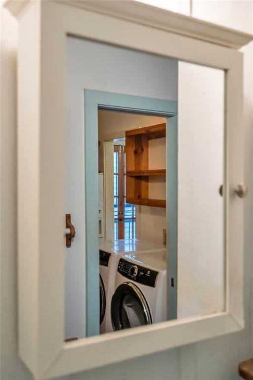 clothes washing area with washer and clothes dryer