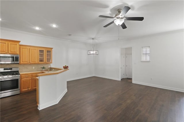 kitchen with pendant lighting, crown molding, appliances with stainless steel finishes, dark hardwood / wood-style floors, and tasteful backsplash