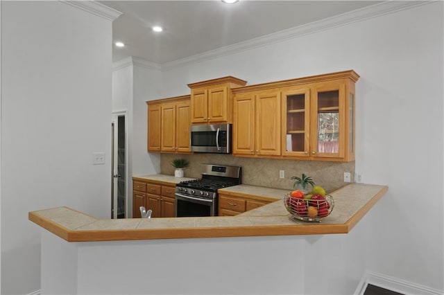 kitchen featuring backsplash, ornamental molding, kitchen peninsula, and appliances with stainless steel finishes