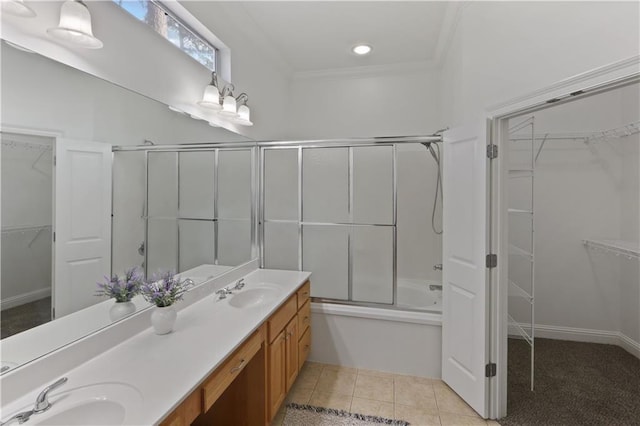 bathroom with tile patterned flooring, ornamental molding, combined bath / shower with glass door, and vanity